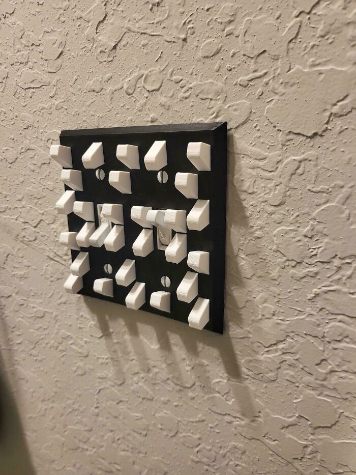 A unique light switch cover featuring multiple small toggle switches, showcasing a cool 3D printer project.
