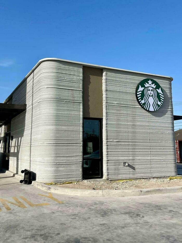 An exterior view of a modern Starbucks building with textured walls, showcasing an innovative 3D printer project.