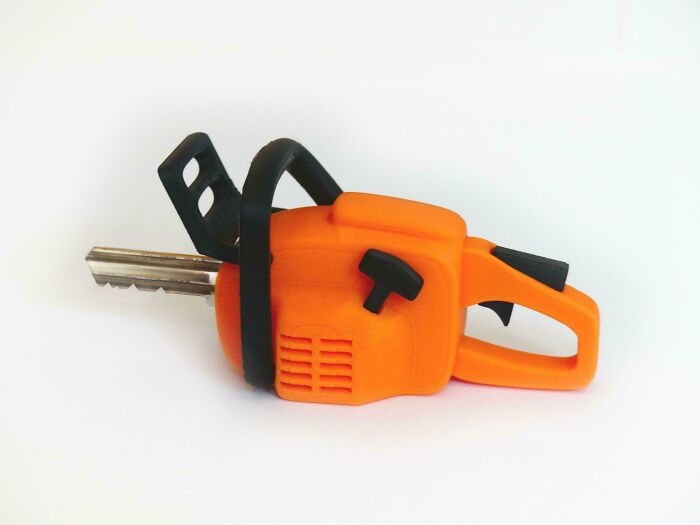 A key with an orange 3D printed chainsaw handle, a unique and cool 3D print project.
