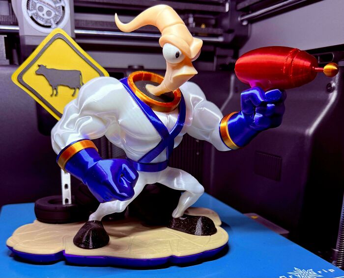 A 3D printer project displaying an intricately designed Earthworm Jim figurine holding a red laser gun.