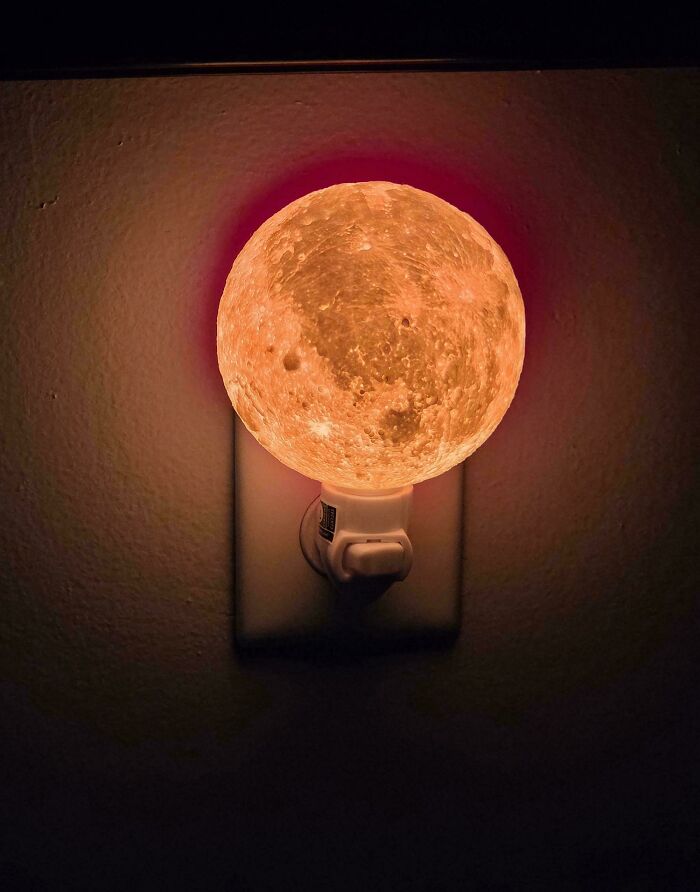 A 3D printer project showcasing a beautiful moon-shaped night light plugged into a wall.