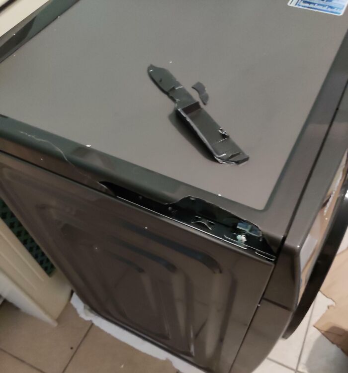 A damaged washing machine with a broken lid, likely due to an entitled man's disregard for boundaries.