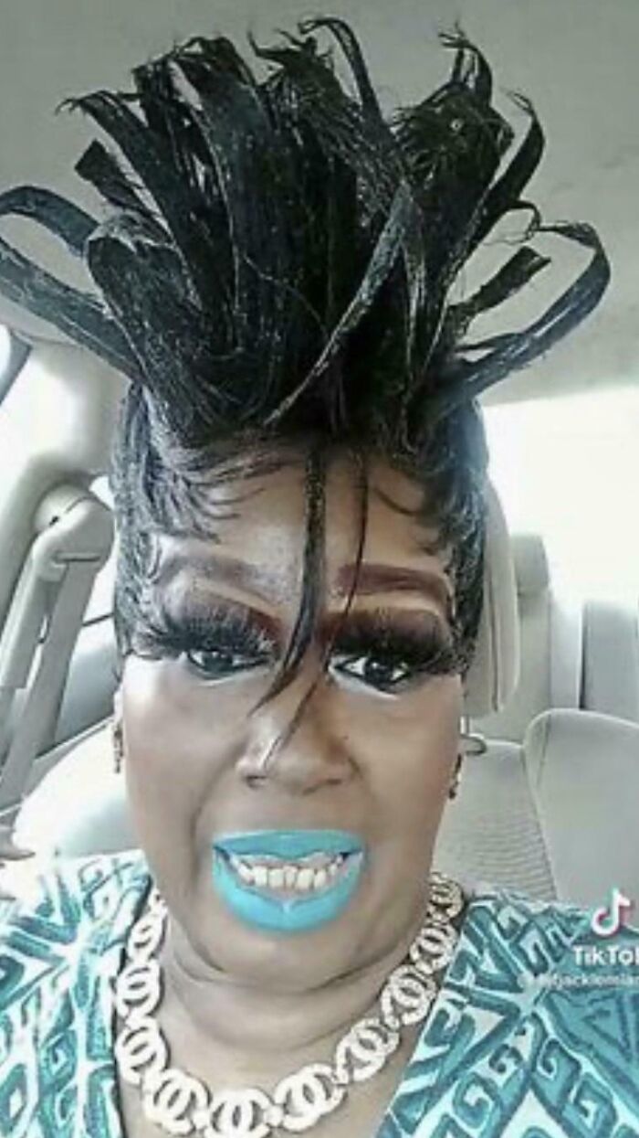 Woman with a high, spiky hairstyle and bold makeup, showing a bad hair mistake.