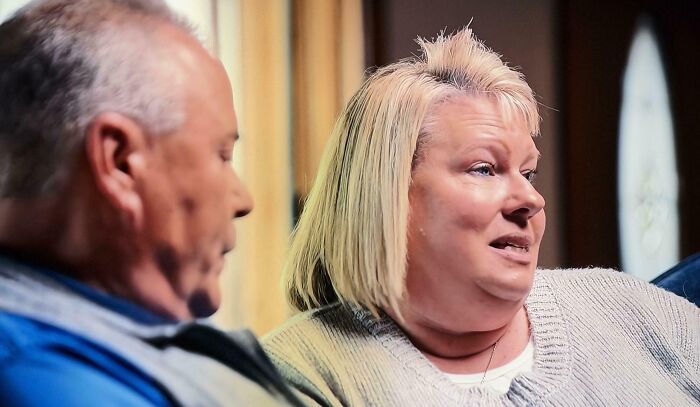 A woman with short blonde hair and a spiky, bad hair mistake, talking to a man.