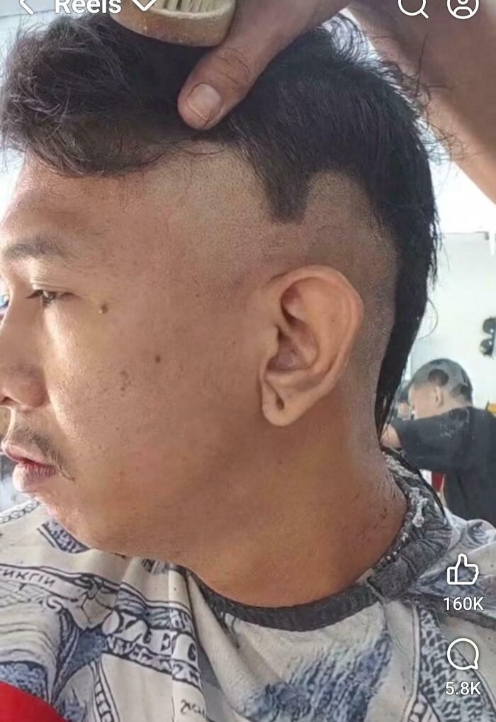 A man getting a haircut, showing a bad hair mistake with unevenly shaved sides and a long mullet.
