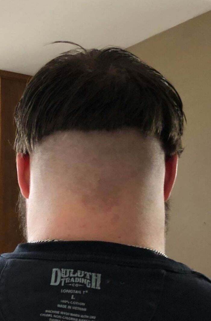A view from the back of a man with a hilariously bad hair mistake, showcasing a severe bowl cut.