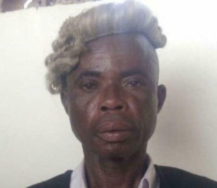 A man with a judge's wig badly styled on his head, showcasing bad hair mistakes.