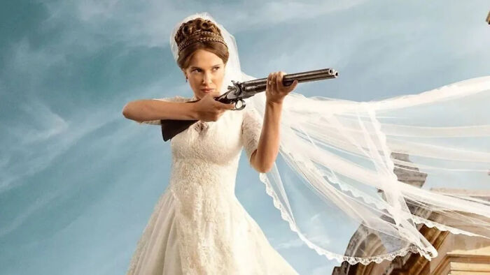 Millie Bobby Brown in a wedding dress, holding a rifle for Enola Holmes 3. Millie Bobby Brown in a wedding dress, holding a rifle for Enola Holmes 3.