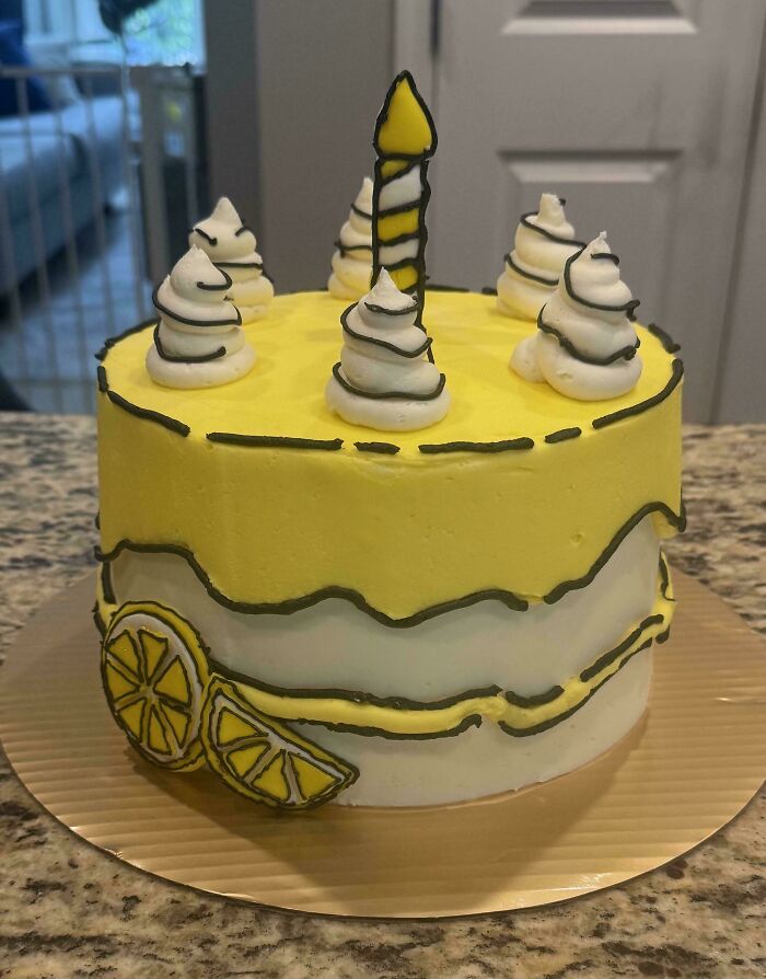 A vibrant yellow and white lemon-themed cake with black outline details, a baker's amazing and delicious treat.