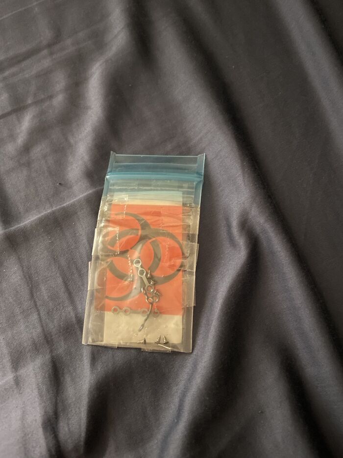 A small clear plastic bag containing biohazard symbols and small metal pieces, representing the amazing human body.
