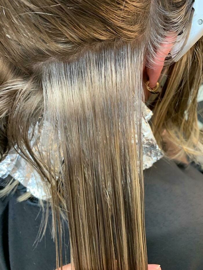 Hair being dyed or bleached, with foil underneath, an example of the amazing human body and its transformations.