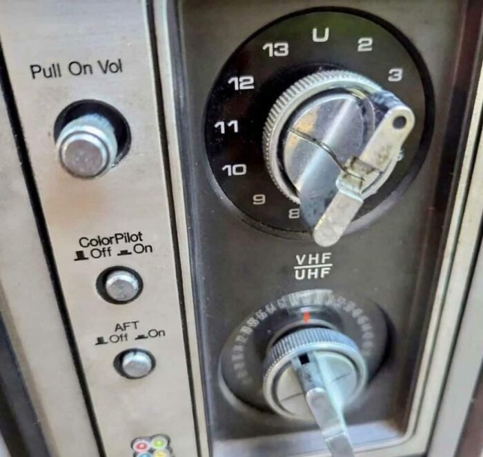 Close-up of an old TV dial with VHF/UHF channels and volume k**b, taking you way back to older technology.