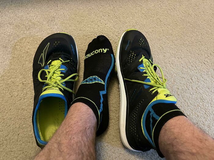 A pair of black and neon green shoes with a black sock in between, showing incredibly satisfying paint matches.
