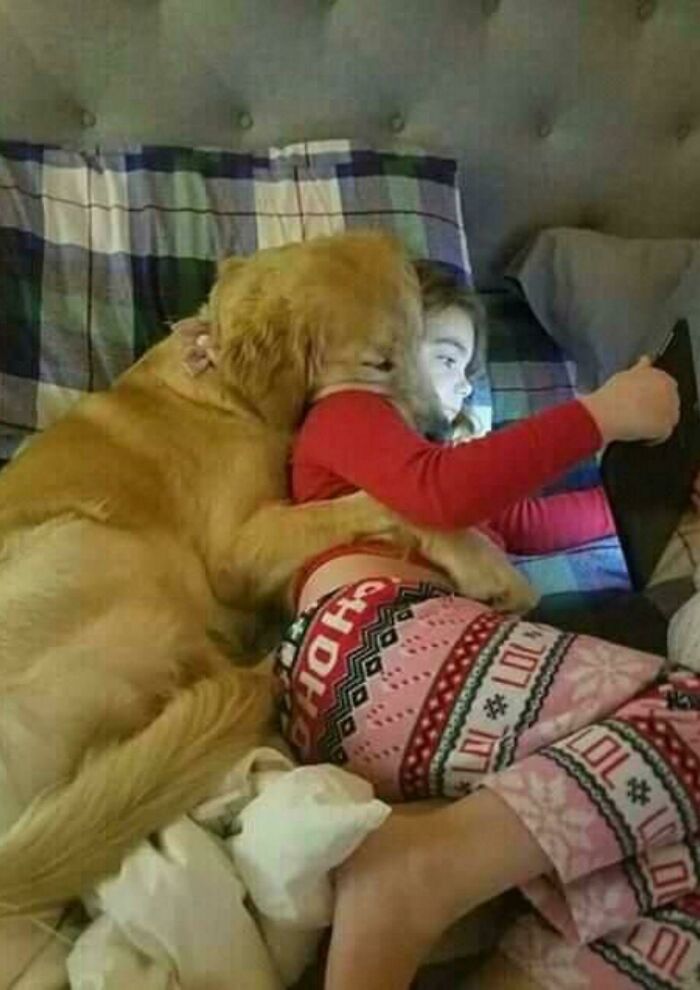 Aww-worthy photo of a golden retriever cuddling with a child, lifting spirits on a bad day.