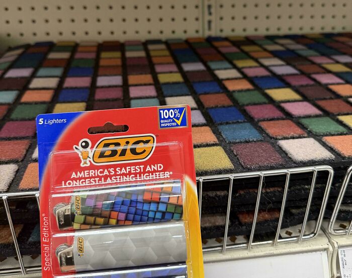 A BIC lighter pack on a shelf, with lighters featuring a colorful cube design that perfectly matches a patterned carpet.