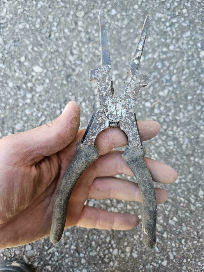 A person holding rusty pliers, featuring the exact color for satisfying paint matches.