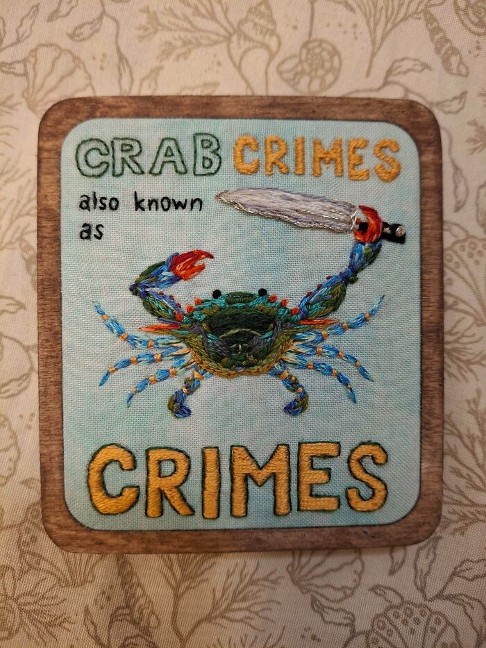 Humorous embroidery projects piece featuring a colorful crab holding a knife with text Crab Crimes