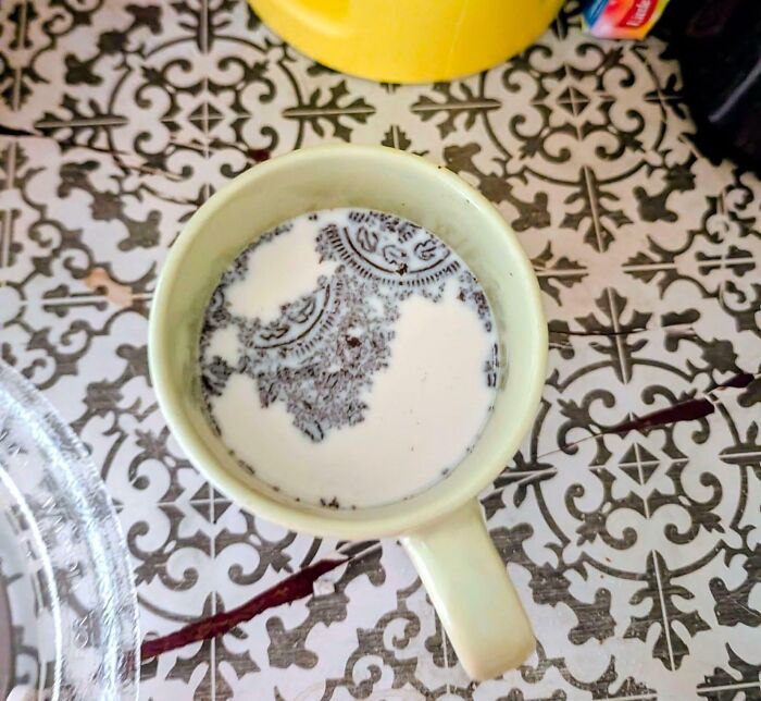 A mug of milk with crushed Oreo cookies creating an intricate pattern, a satisfying paint match.