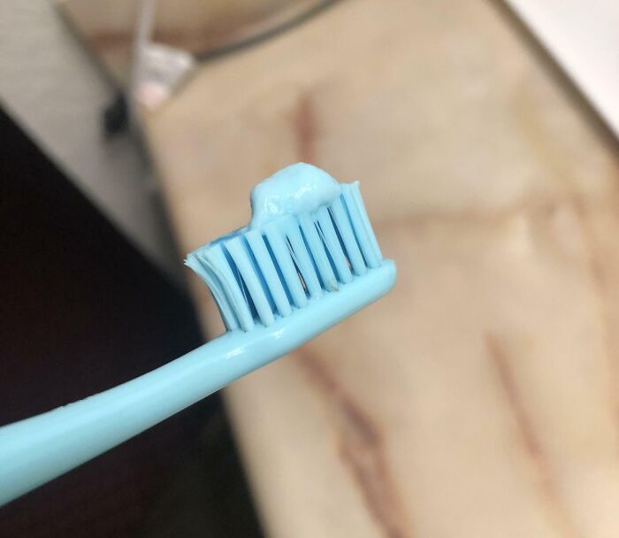 A blue toothbrush with toothpaste perfectly matching the brush. A satisfying paint match.