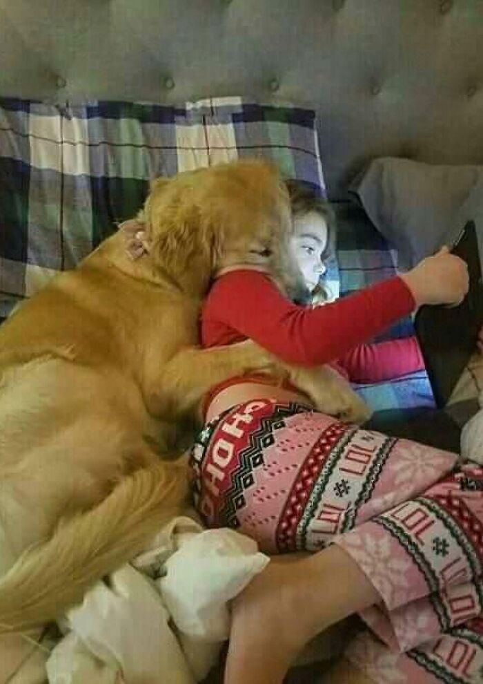 Aww-worthy photo of a golden retriever cuddling with a child, lifting spirits on a bad day.