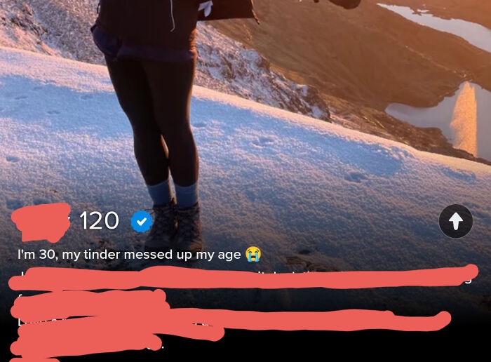 A person standing on a snowy mountain, with a Tinder profile showing an incorrect age, a cringe Tinder profile example.