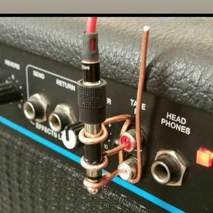 Copper wire and an audio jack are used in a wild way to fix something on a speaker's input panel.