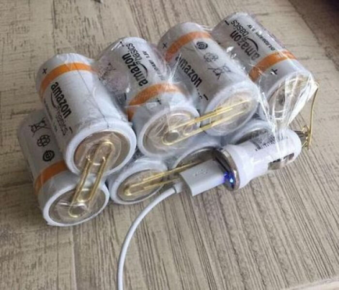 A DIY power bank made from Amazon Basics batteries, paperclips, and a USB car charger to fix a d**d phone.