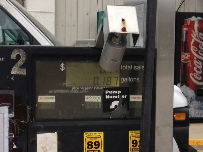 Wild and unhinged way to fix a broken gas pump with a security camera dangling from the top.