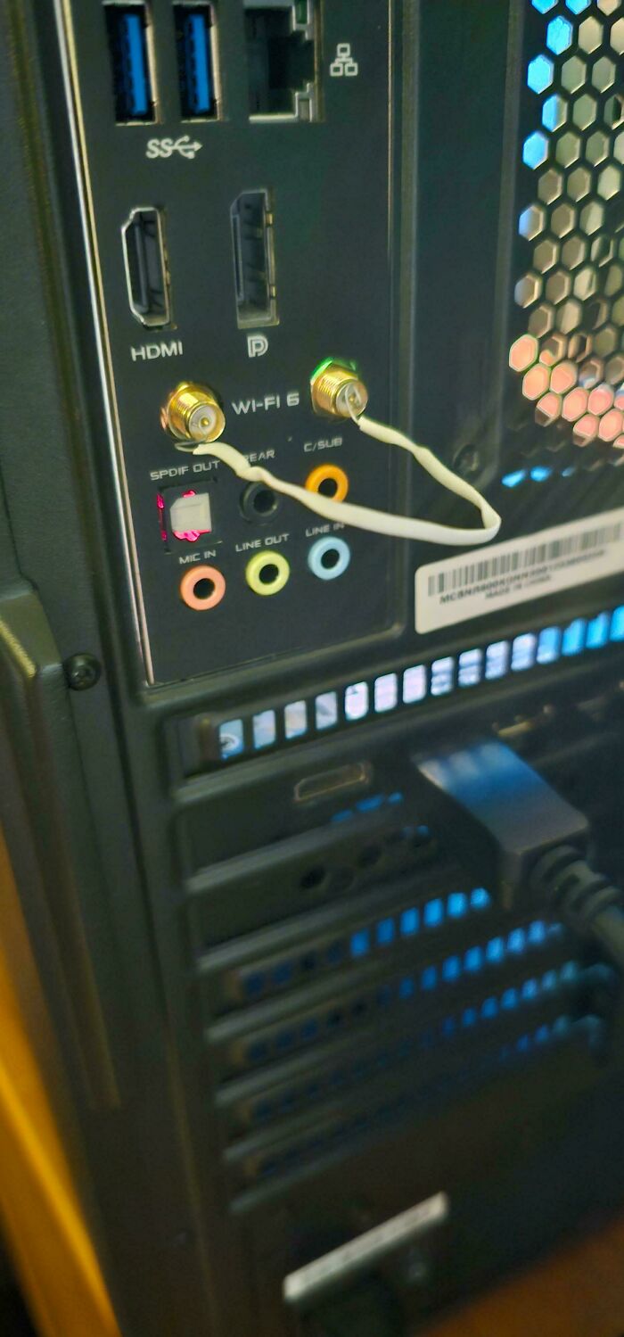 The back of a computer with Wi-Fi antennas plugged into audio jacks, an unhinged way to fix a setup.