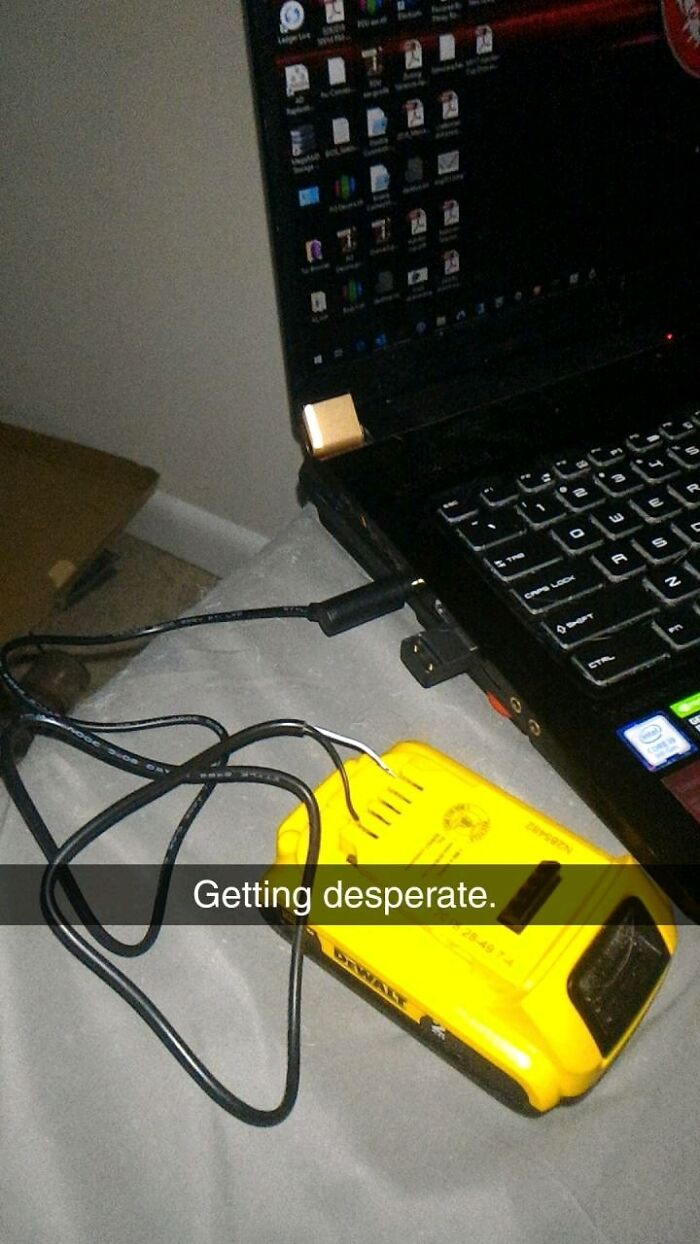 A laptop being charged by a Dewalt battery, an unhinged way to fix something.