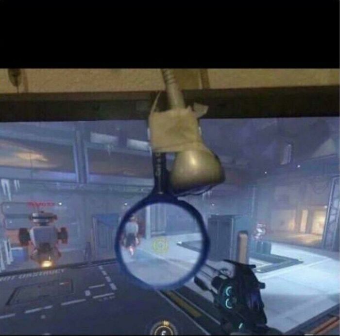 A magnifying glass taped to a screen to zoom in on a video game, an unhinged way to fix visibility.