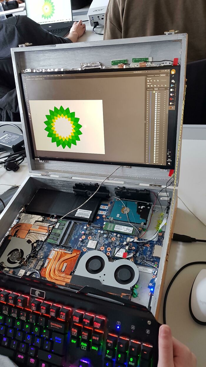 An open laptop with internal components exposed, displaying a BP logo, an unhinged way to fix or build.