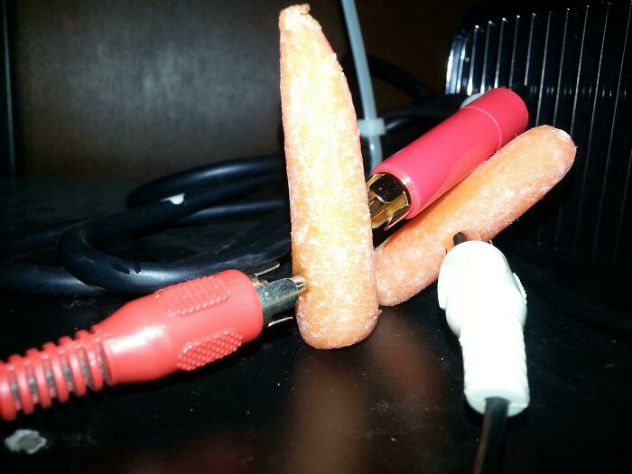 Carrots used in a wild and unhinged way to fix audio cables, acting as makeshift connectors.