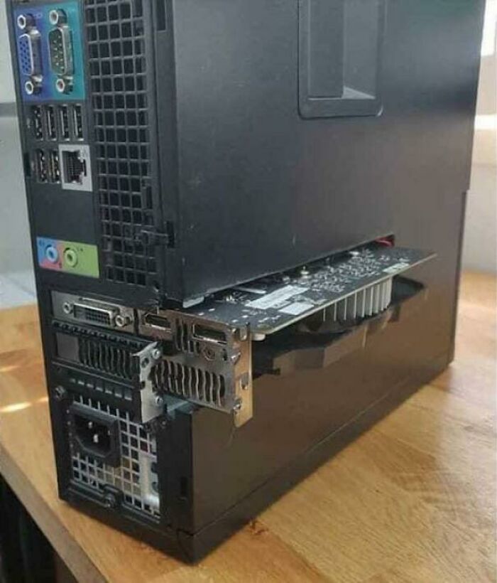 A computer case with a graphics card unhinged and sticking out, demonstrating a wild way to fix something.