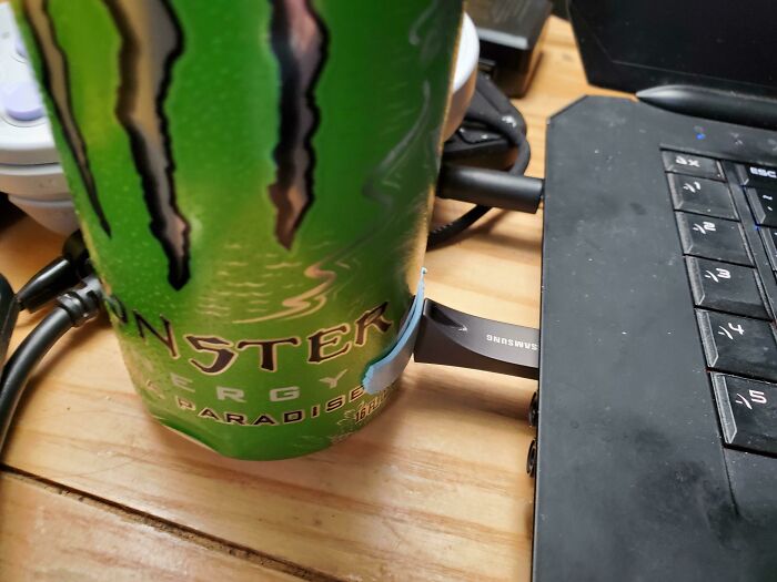 A Monster Energy drink used to unhinged ways to fix something with a USB drive into a laptop.