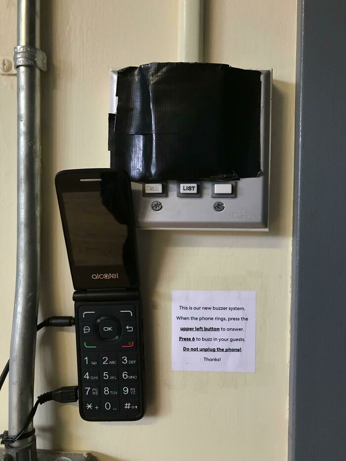 An Alcatel flip phone is taped to a wall as a buzzer system, a wild way to fix something.