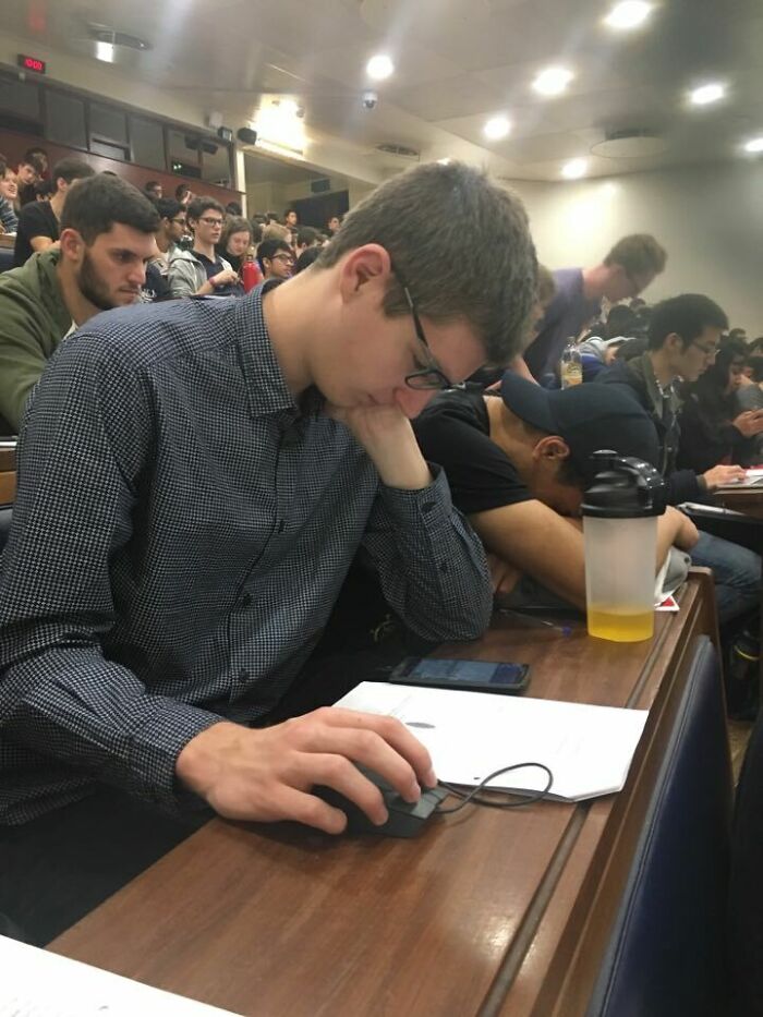 A student asleep with his head on his hand while using a mouse, showing an unhinged way to fix tiredness.