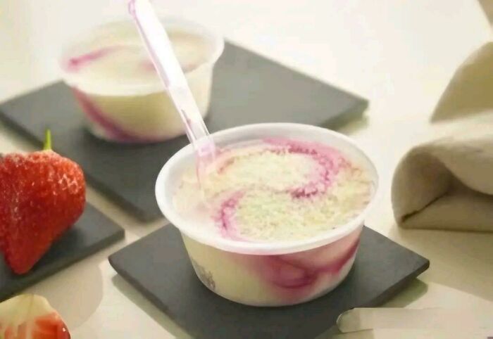 A close-up of swirled ice cream cups with a strawberry, evoking good memories of life in the 80s.