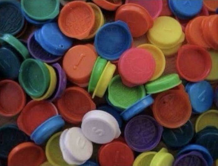 A pile of colorful, assorted POGs game pieces, a popular toy, bringing back good memories of life in the 80s.
