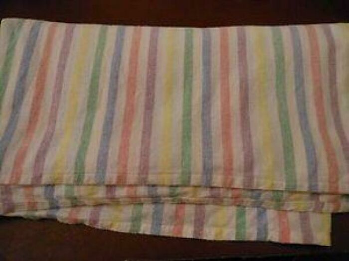 A folded pastel striped blanket, a nostalgic item from good memories of life in the 80s.