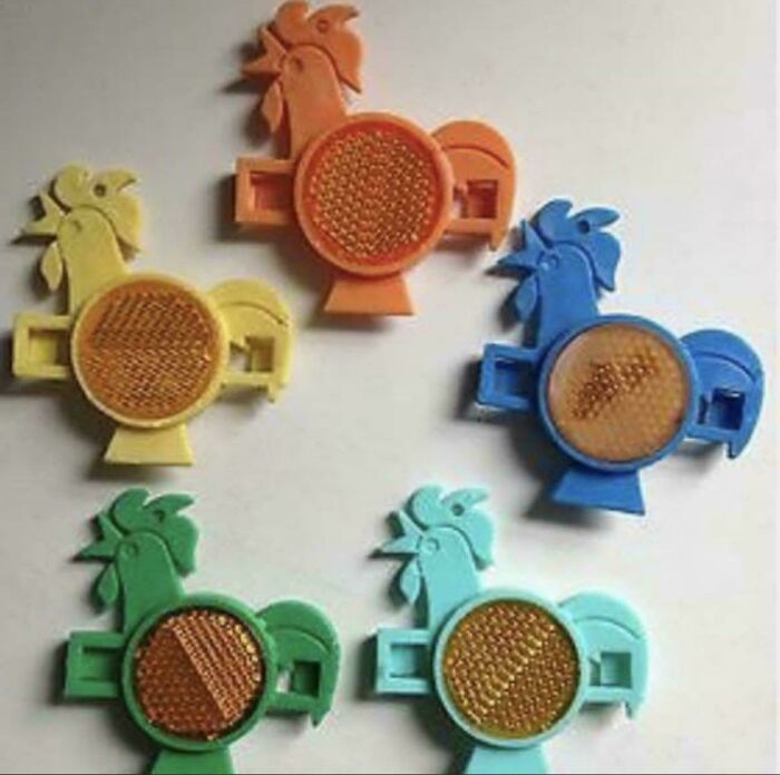Five colorful rooster-shaped bicycle reflectors, nostalgic items from the 80s, bringing back good memories.