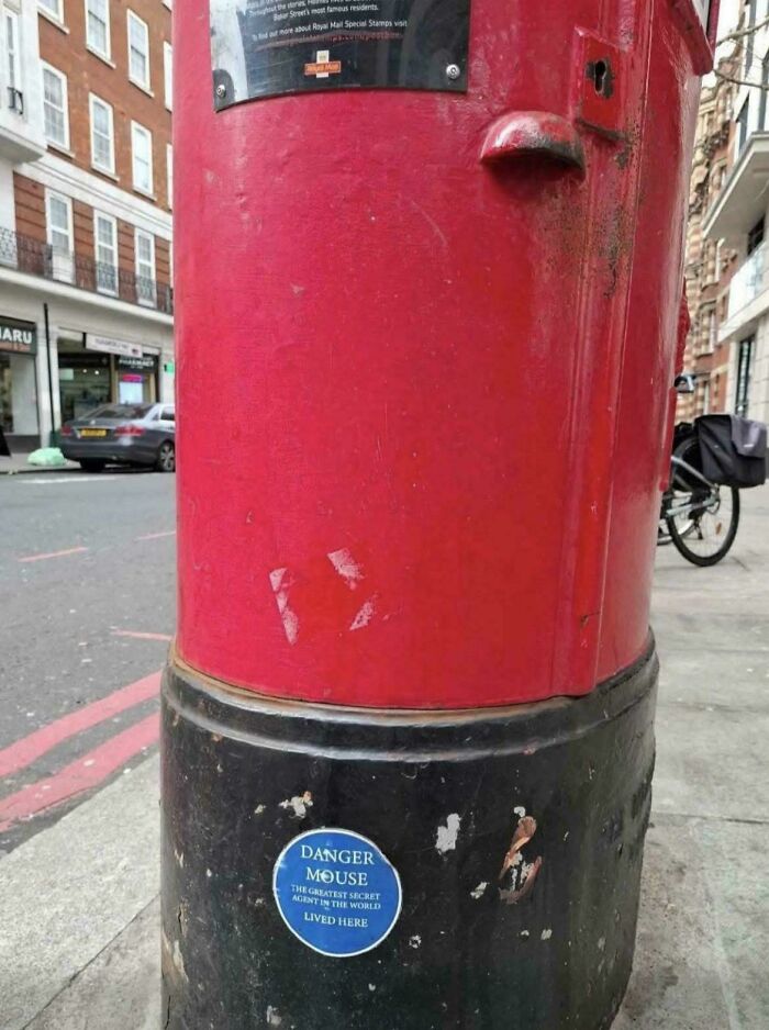 A classic red British post box with a Danger Mouse sticker, a nostalgic sight bringing back good memories of the '80s.