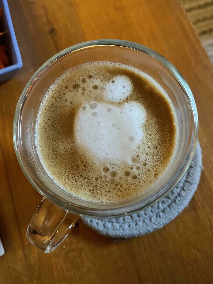 A coffee with foam art resembling an Apple logo, a photo that may need a second look to comprehend.