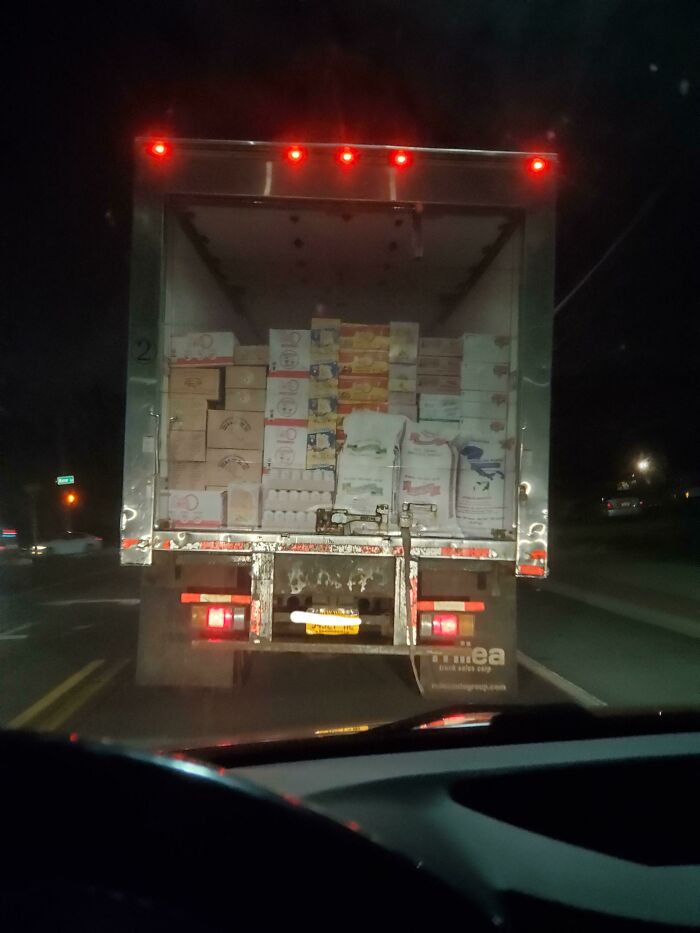 The back of a semi-truck loaded with boxes, an image that you may need to look twice at to understand.