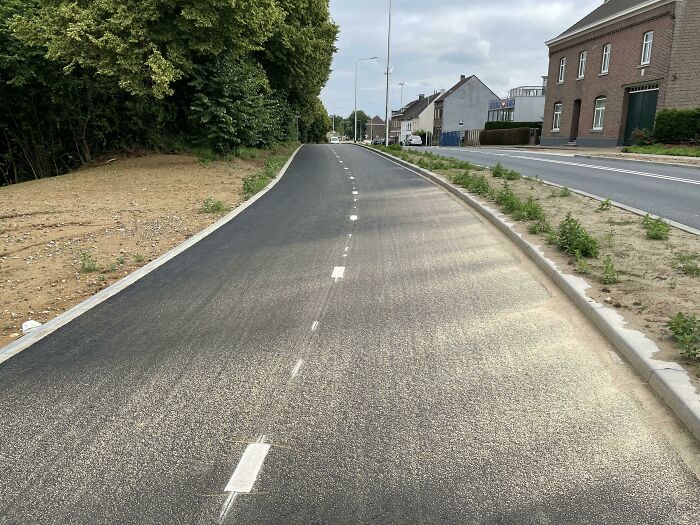 A newly paved road with white dashed lines, showcasing a perspective that may need a second look.