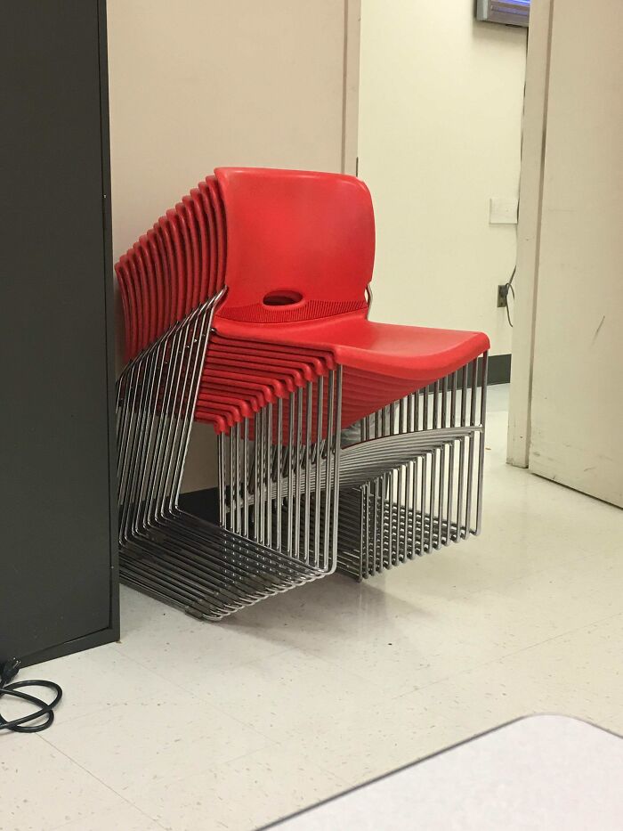 A stack of red chairs that you may need to look twice at, forming an optical illusion.