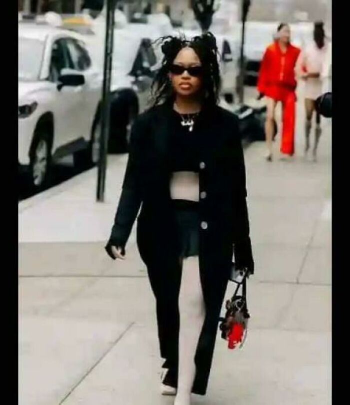 A stylish person in a black jacket and white leggings walking on a city street, one of the photos needing a second look.
