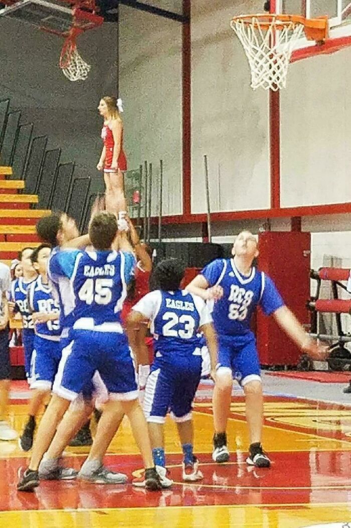 A cheerleading stunt creates an optical illusion, making it seem like a cheerleader is floating to look twice at.