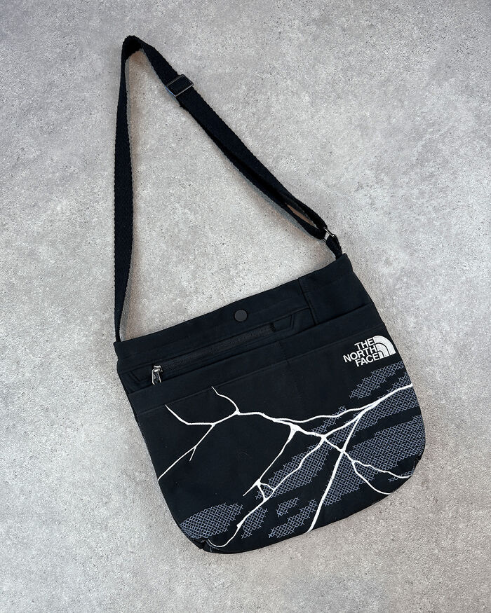 Repurposed bag made from old junk, featuring a lightning design and brand logo.