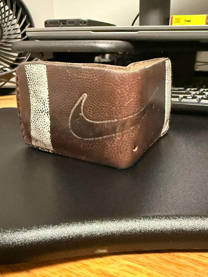 An old junk football-themed wallet, showcasing creativity and reuse on a dark desk.